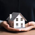 A man holding a model of a house