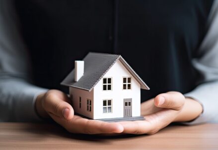 A man holding a model of a house