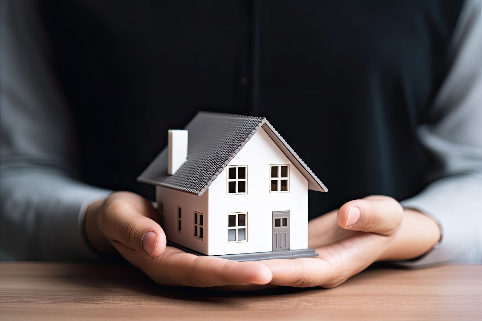 A man holding a model of a house