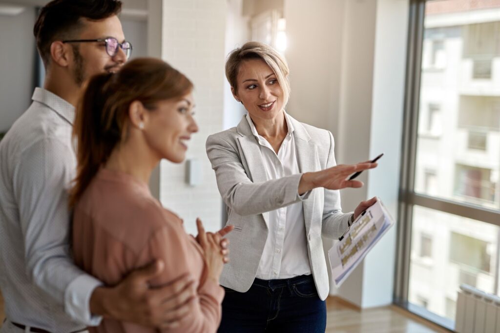 A female realtor shows an apartment to a couple