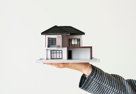 A woman holding a model of a house