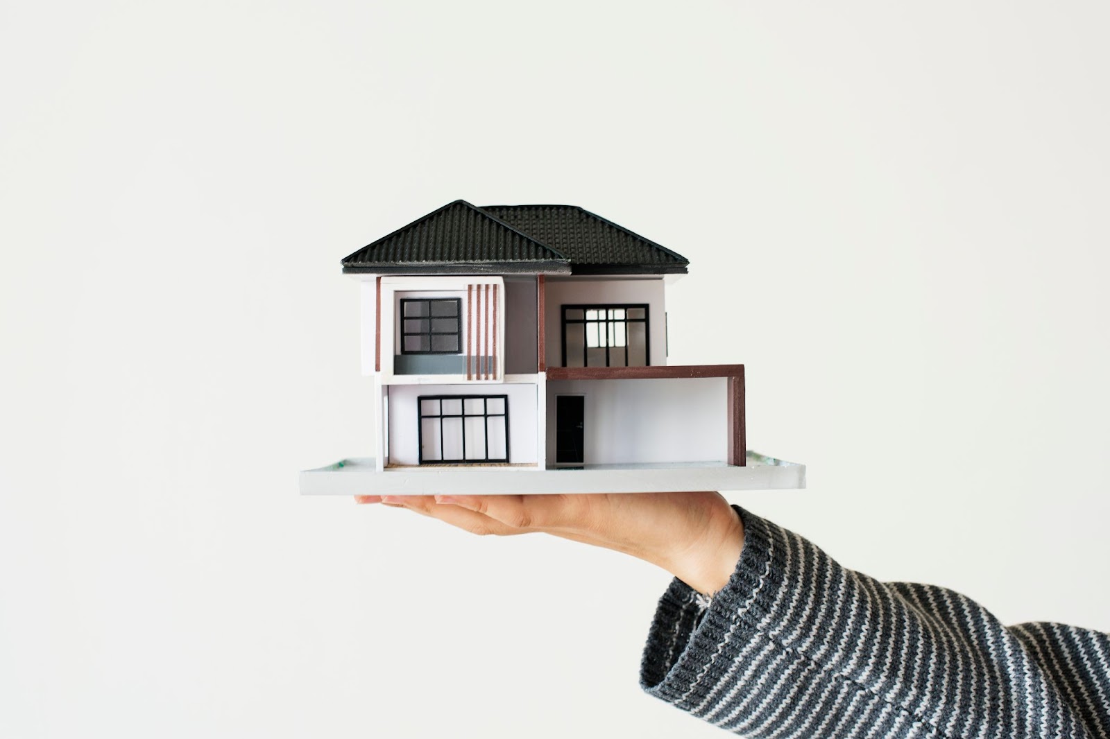 A woman holding a model of a house
